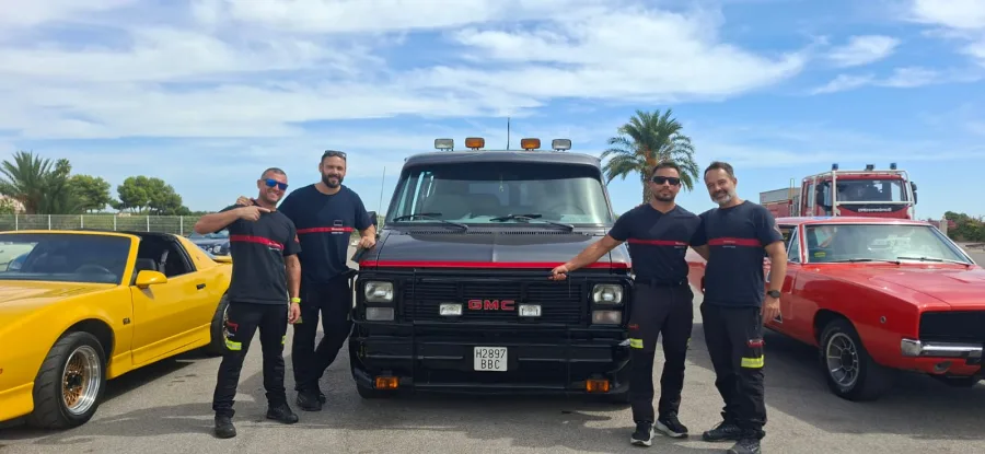 The A-Team van beside classic cars and its crew at a car meet